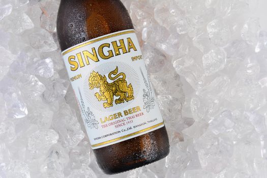 IRVINE, CA - JANUARY 11, 2015: Closeup of a single bottle of Singha Beer on ice. Produced by Boon Rawd Brewery it is the only brewery permitted to display the royal Garuda on the bottleneck.