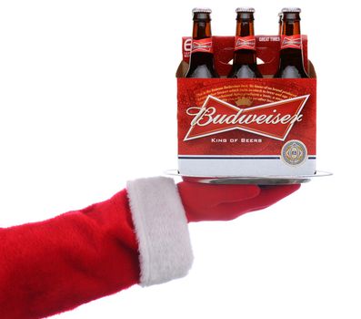 IRVINE, CALIFORNIA - 3 SEPT 2020: Santa Claus holding a serving tray with a 6 pack of Budweiser Beer over a white background.