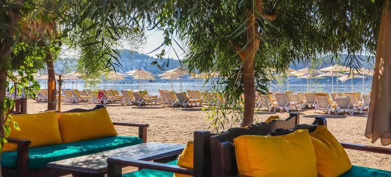 Beautiful beach on the shores of the calm blue bay of the Aegean Sea in the early morning. Beach vacation and holiday destination concept. Bitez, Bodrum, Turkey