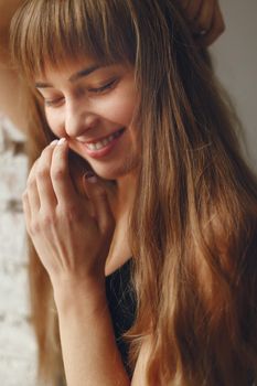 Beautiful girl in a studio. Stylish girl near gray wall. Lady in a black t-shirt