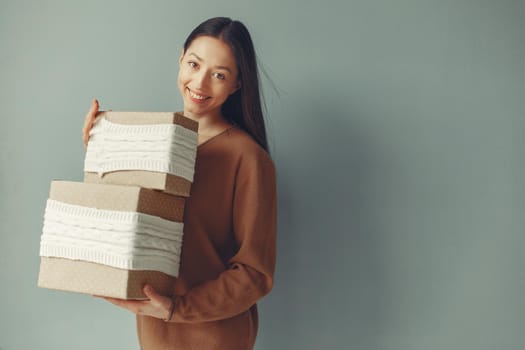 Woman with presents. Girl in a brown sweater. Lady in a studio.