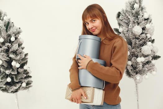 Woman with presents. Girl in a brown sweater. Lady in a studio.