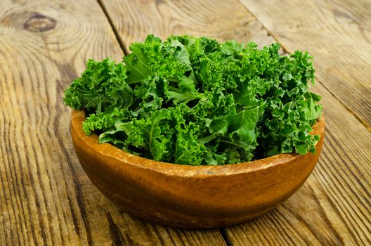 Fresh green sabellica leaves on wooden background, healthy organic food. Studio Photo