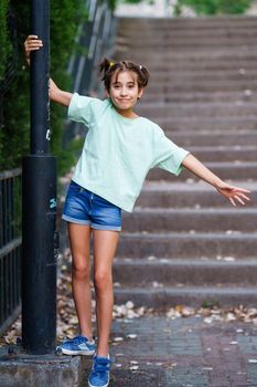 Nine-year-old girl standing on the steps of a city park.