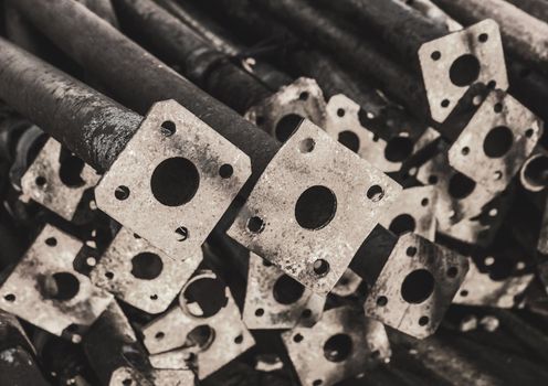 Pile of old industrial temporary fencing pipes at a construction site.