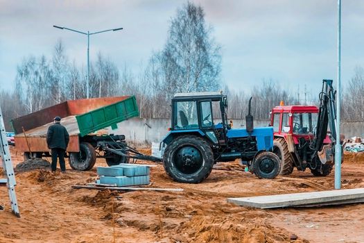 Unloading land and building materials from a tractor trailer at a construction site.