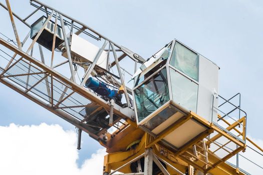 Tower building equipment construction crane cabin close-up on blue sky background.