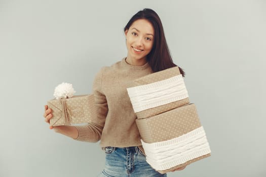 Woman with presents. Girl in a brown sweater. Lady in a studio.