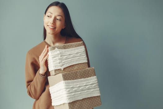 Woman with presents. Girl in a brown sweater. Lady in a studio.