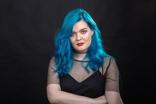 People and fashion concept - Close up portrait of woman with blue long hair over black background.