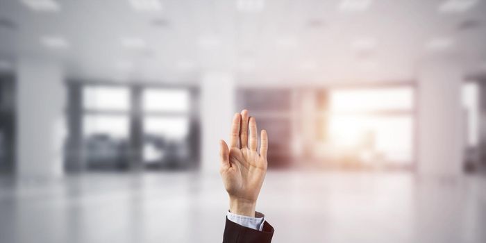 Close of businesswoman hand touching screen with palm and office at background