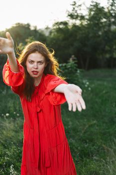 attractive woman in red dress outdoors in freedom field. High quality photo