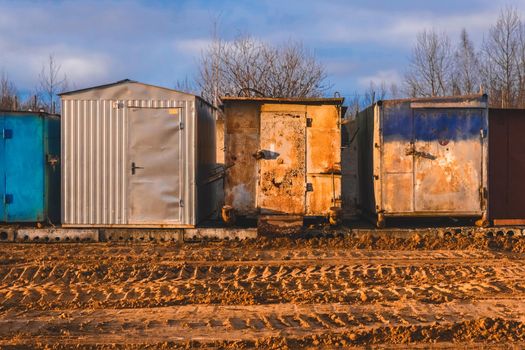 Old iron trailers on the construction site with footprints and patterns from wheels and tires of industrial transport on the sand.