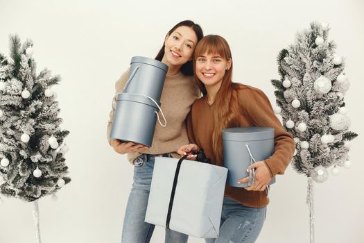 Women with presents. Girl in a brown sweater. Ladies in a studio.