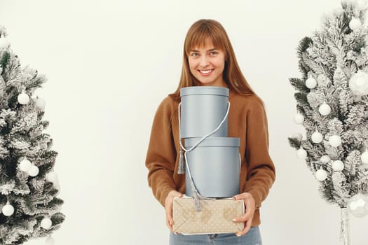 Woman with presents. Girl in a brown sweater. Lady in a studio.