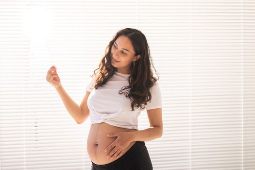 Pregnant woman touching her belly, copy space. Pregnancy and maternity leave.