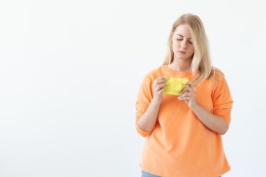 Photographer, hobby and leisure concept - Young blond woman with retro camera on white background with copy space.