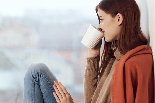 woman looking out the window on the windowsill Comfort weekend rest. High quality photo