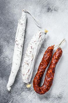 Spanish salami, fuet and chorizo sausages on a kitchen table. White background. Top view.