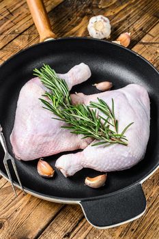 Raw chicken legs in a pan ready for the Grill. wooden background. Top view.