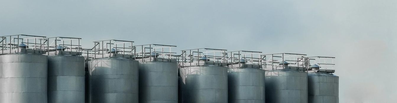 Industrial tanks for storing, receiving and preparing liquid products against a blue sky.