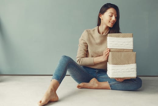 Woman with presents. Girl in a brown sweater. Lady in a studio.