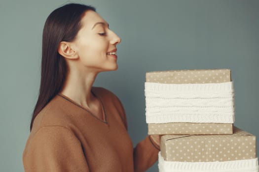 Woman with presents. Girl in a brown sweater. Lady in a studio.