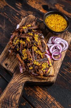 BBQ Texas Sandwich with slow roasted brisket beef meat. Dark wooden background. Top view.