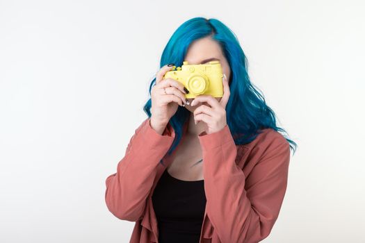 Photographer, hobby and leisure concept - Young blond woman with retro camera on white background with copy space.