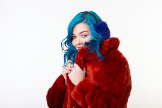 People, protection animals and fashion concept - Beautiful girl with blue hair dressed in red warm jacket in artificial fur and earmuffs.