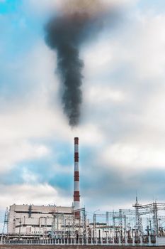 Environmental problem, environmental pollution, smoke from the pipe of an thermal power plant against a blue sky.