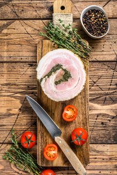 Italian traditional bacon pancetta on a cutting board. Wooden background. Top view.