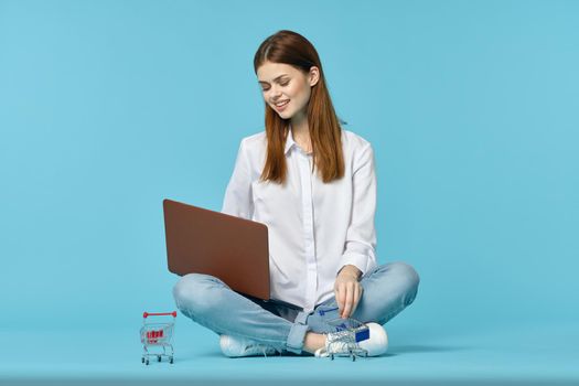 woman with laptop learning internet online education blue background. High quality photo
