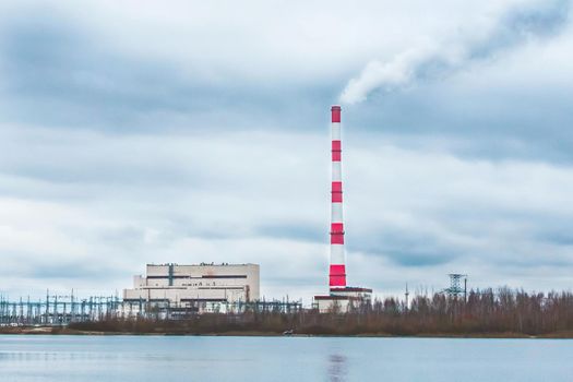 Environmental problem, environmental pollution, smoke from the pipe of an thermal power plant against a blue sky.