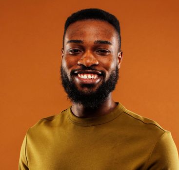 young pretty african american man posing cheerful on brown background, lifestyle people concept close up