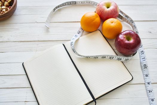 notepad on table measuring tape fruit breakfast nutritional fitness. High quality photo