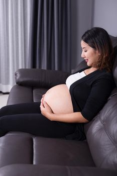 portrait of pregnant woman resting at home on sofa