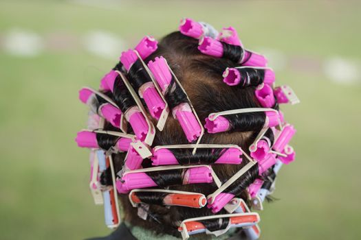 senior woman with hair roller, back