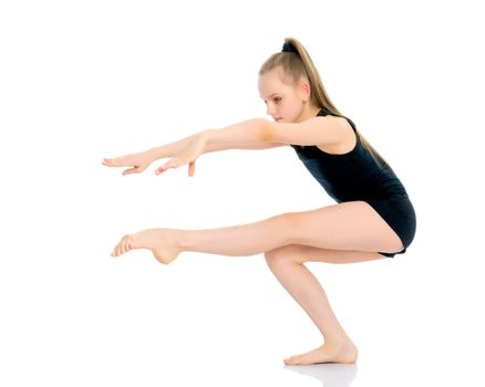A girl gymnast performs an acrobatic element. The concept of childhood, sport, healthy lifestyle. Isolated on white background.