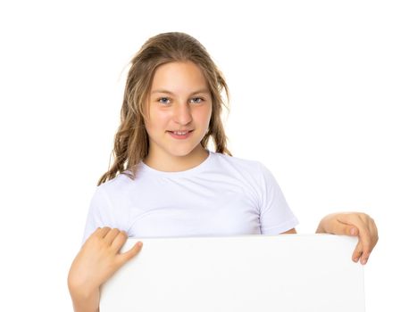 A little school girl in a white empty T-shirt. The concept of advertising and design of T-shirts. Isolated on white background.