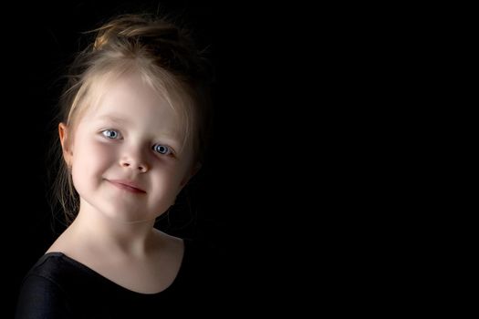 Beautiful little girl with a flower in her hand. The concept of style and fashion. On a black background.