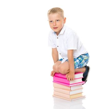 A cute little boy, a preschooler with books. The concept of education, the intellectual development of the child in the family. Isolated on white background.