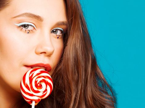 young pretty adorable brunette woman with curly hair close up like doll makeup on blue background, posing emotional, lifestyle people concept