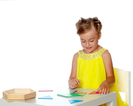 A little girl in Montessori kindergarten sits at a table and studies Montessori stuff. The concept of school and preschool education, harmonious development of the child. Isolated on white background.