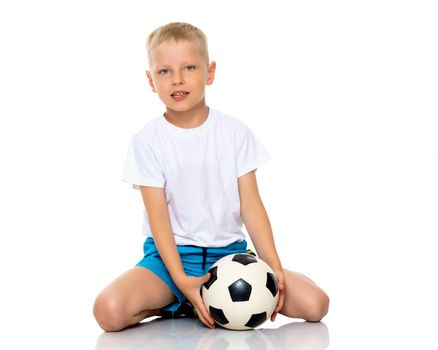 Cute little boy is playing and posing in the studio with a soccer ball. The concept can be used to advertise football clubs, sports outfits, healthy lifestyles. Isolated on white background.