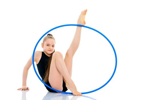 A girl gymnast performs an exercise with a hoop. The concept of gymnastics and fitness. Isolated on white background.