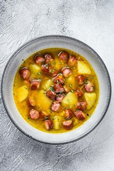 German Split pea soup with smoked sausages. White background. Top view.