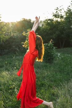 attractive woman in red dress outdoors in freedom field. High quality photo