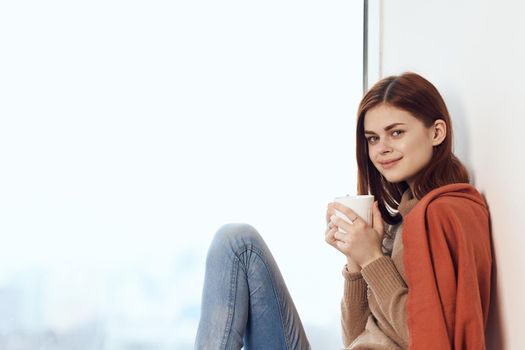 woman looking out the window on the windowsill Comfort weekend rest. High quality photo