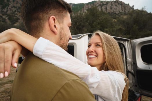 Happy loving couple hiking and hugging in mountains, close up